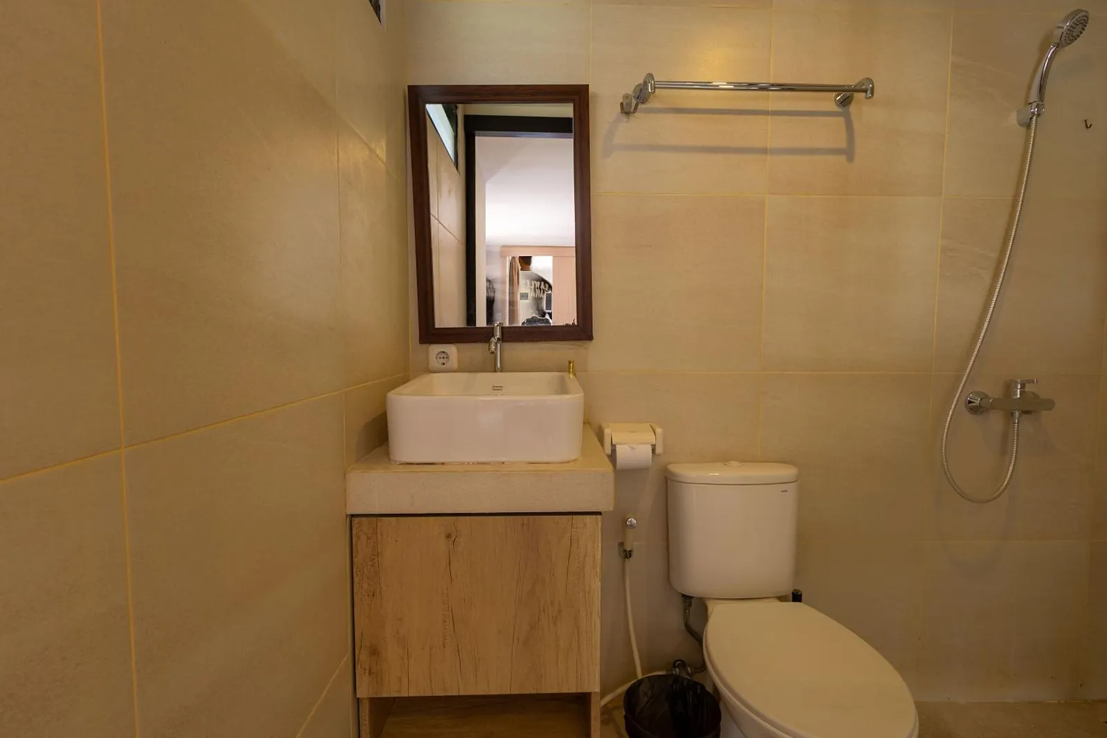 Ensuite bathroom in warm stone tiles with a vessel basin and rain shower