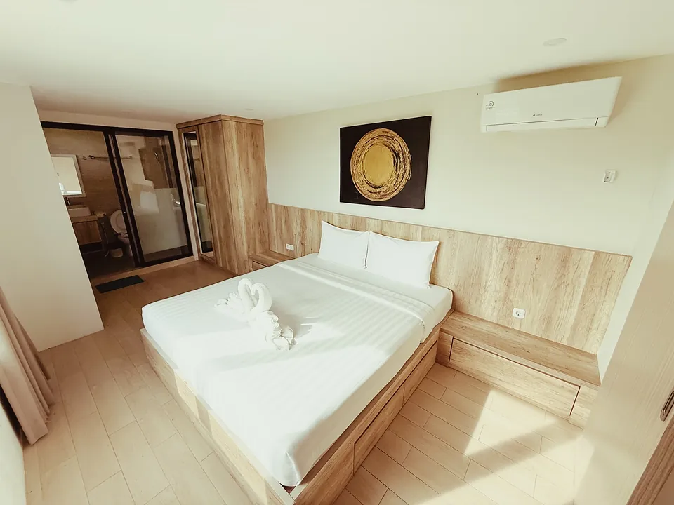 A suite bedroom with a carved gold artwork above the bed