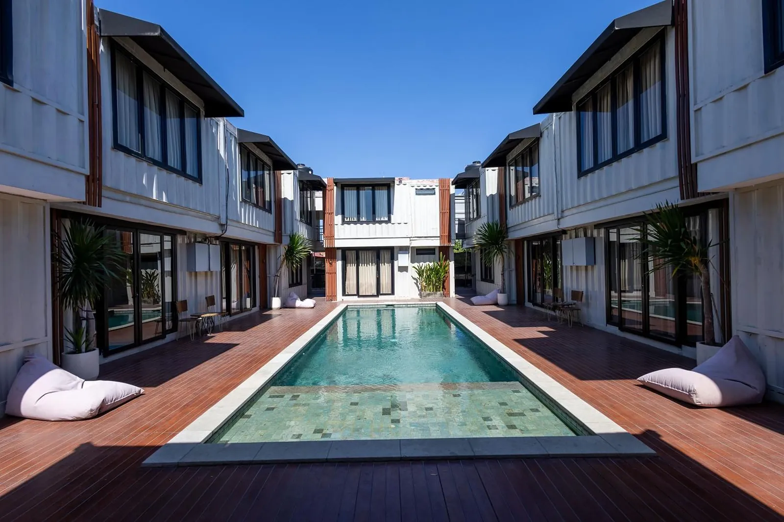 Looking down the pool from the deep end, teak decking and beanbags on both sides