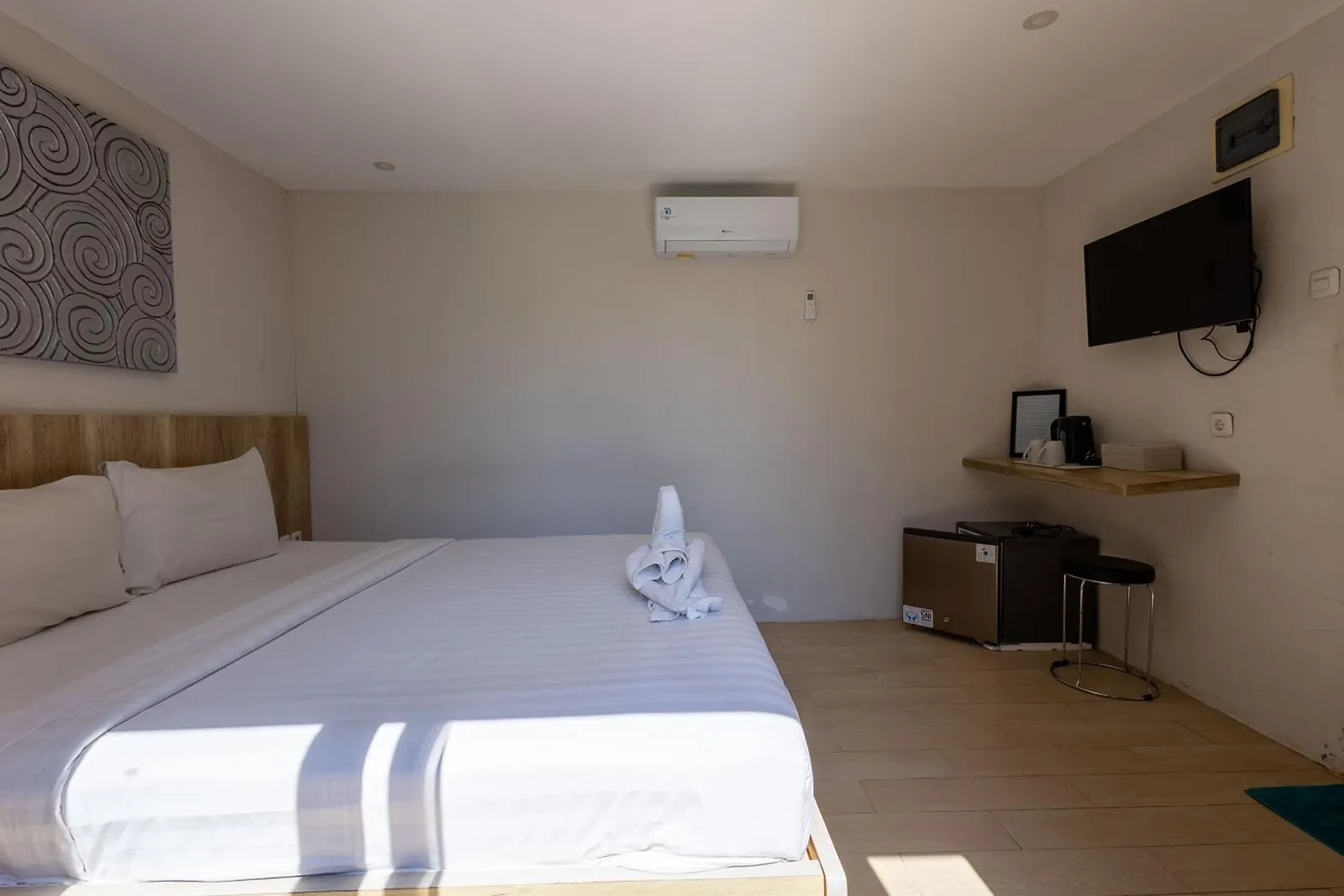 Deluxe Studio: bed, wall-mounted TV and a small writing desk