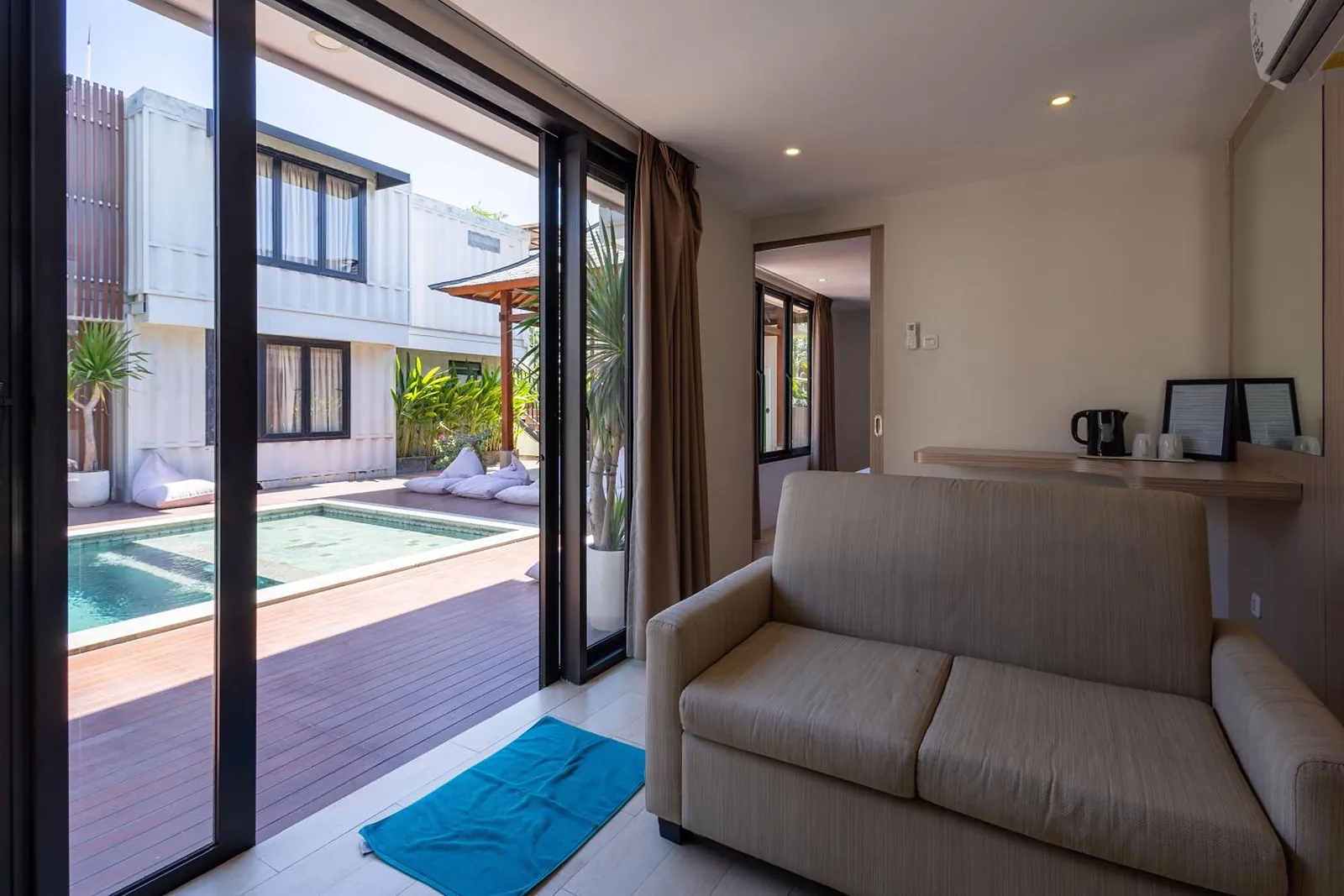 Pool-View Suite: a linen sofa facing glass doors that open onto the pool